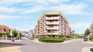 A multi-story residential building with balconies, a central courtyard, and a street view. - Beautiful penthouse flat with central location (Koksijde)