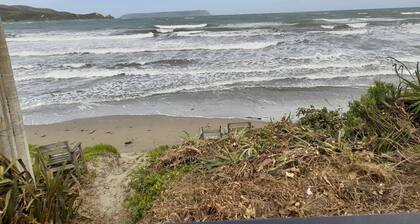 Absolute Beach Front, 25 mins from Wellington Sunset spa deck. Cosy Fire lounge.