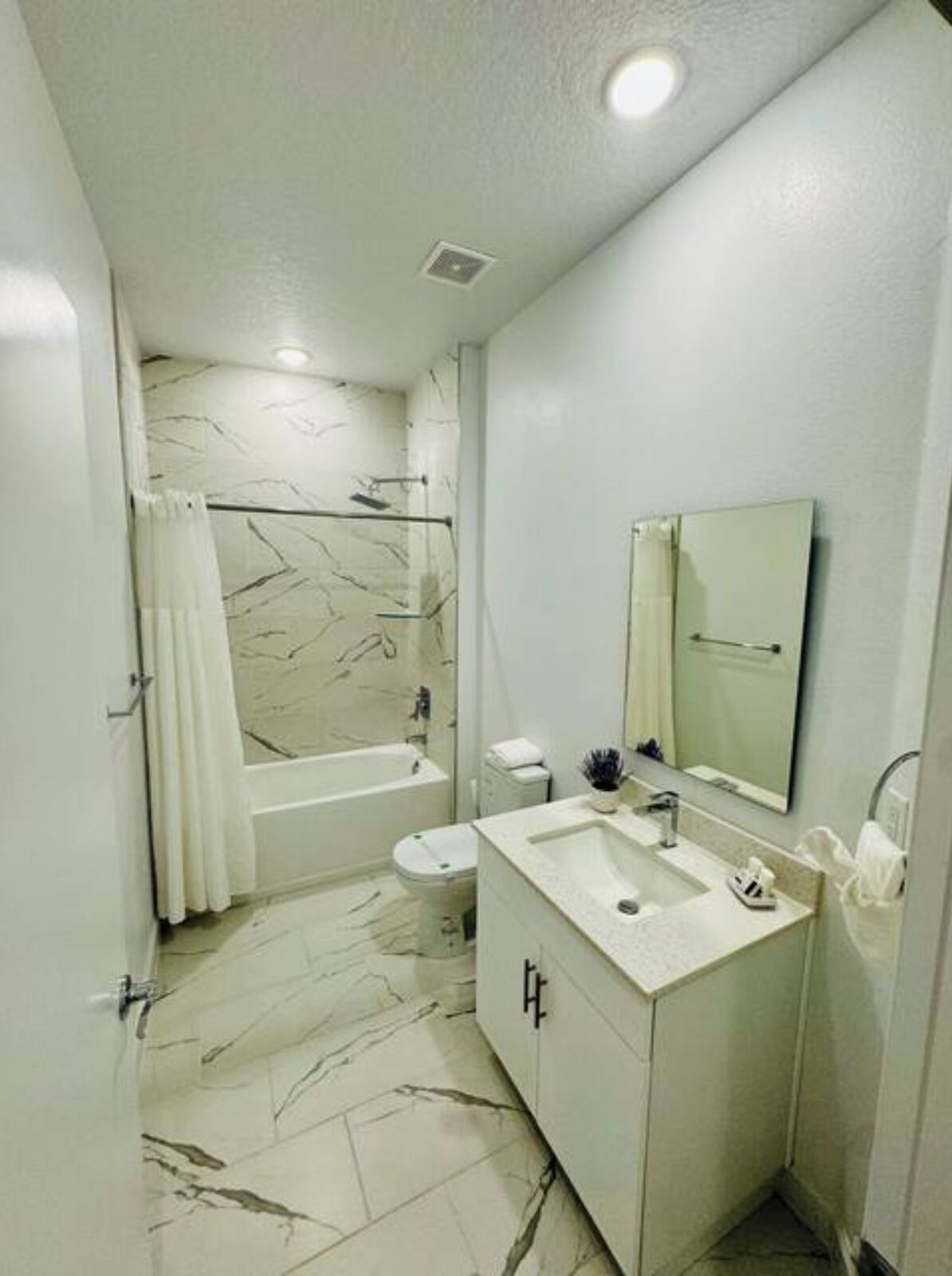 A modern bathroom with a bathtub, toilet, and sink.