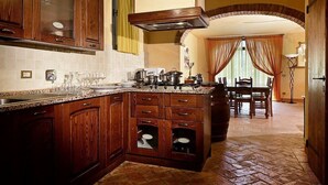 Una cocina con armarios de madera, encimera de granito y comedor con mesa y sillas.