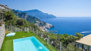 Ein Pool mit freiem Blick auf die Küste und die Berge.