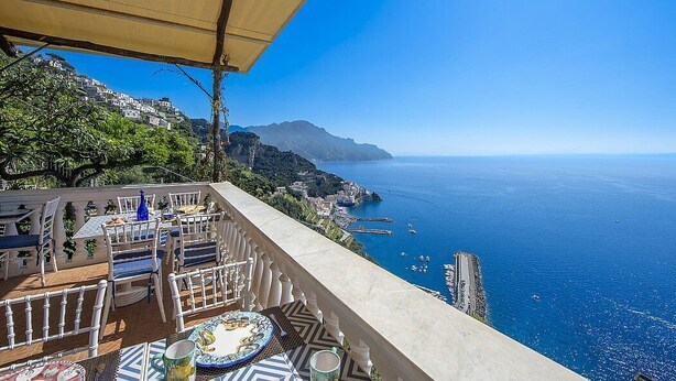 Eine Terrasse mit Sitzgelegenheiten und Blick auf die Küste.