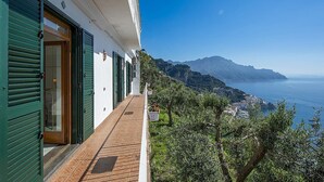Ein Balkon mit Blick auf das Meer und die Berge.