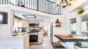 Una cocina amplia con armarios de madera, una isla grande y una zona de comedor con banco.