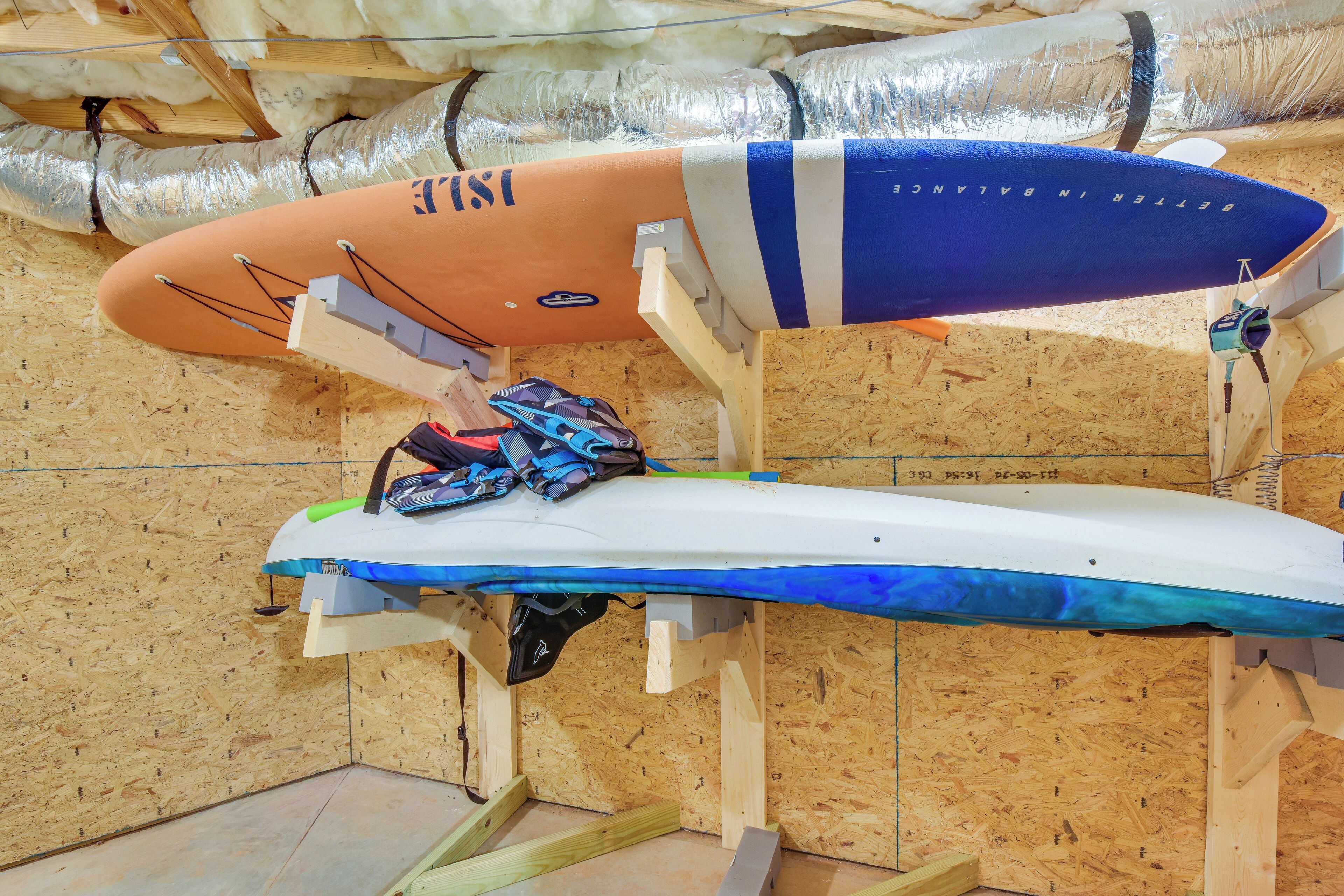 Twee surfplanken staan op houten standaard in een werkplaats met isolatie en houten wandpanelen.