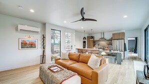 A modern living room with a leather sofa, a coffee table, and a ceiling fan. - Modern Cabin Living! Mtn-View Gem in Munds Park (Munds Park)