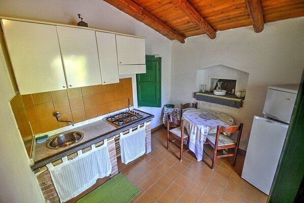 Une cuisine compacte équipée d’une cuisinière, d’un évier et d’un petit coin repas avec une table et des chaises.