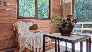 Ein Holzblockhaus-Interieur mit einer Bank, einem Tisch und einer Topfpflanze.