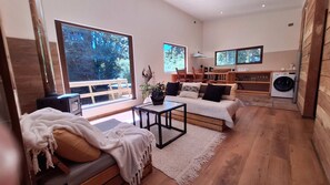 A modern living room with a sofa, a coffee table, a TV, and a washing machine.