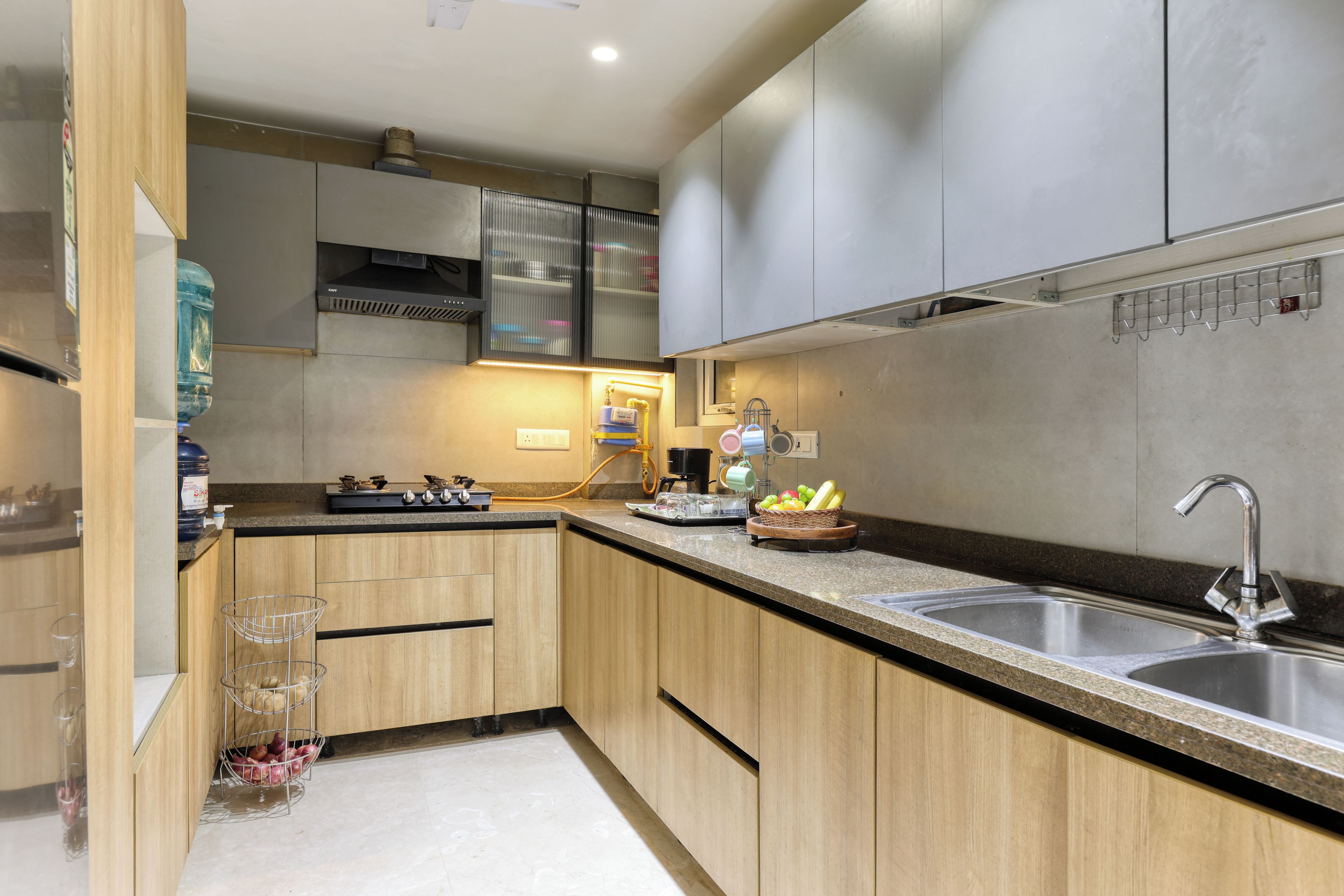 A modern kitchen with wooden cabinets, a stainless steel sink, and a built-in range hood.