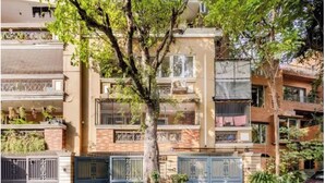 Un immeuble résidentiel doté de nombreux balcons, d’une entrée sécurisée et entouré de verdure.
