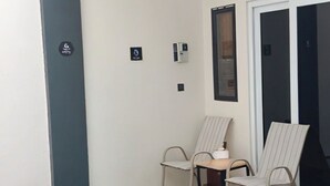 Une petite piscine intérieure avec deux chaises longues, un sol carrelé et une porte donnant sur une autre pièce.