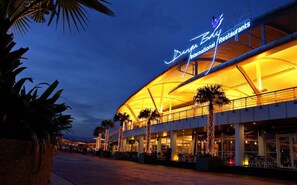 A large, modern building with a curved roof and a sign that reads "Danya Bay International Restaurants." - Bright 2BR Suasana Near JB Sentral CIQ (Johor Bahru)