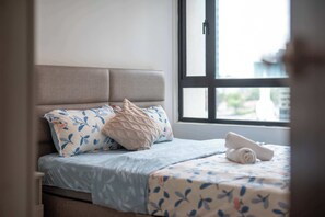Ein Bett mit Kopfstütze, einem Fenster und einem Handtuch darauf.