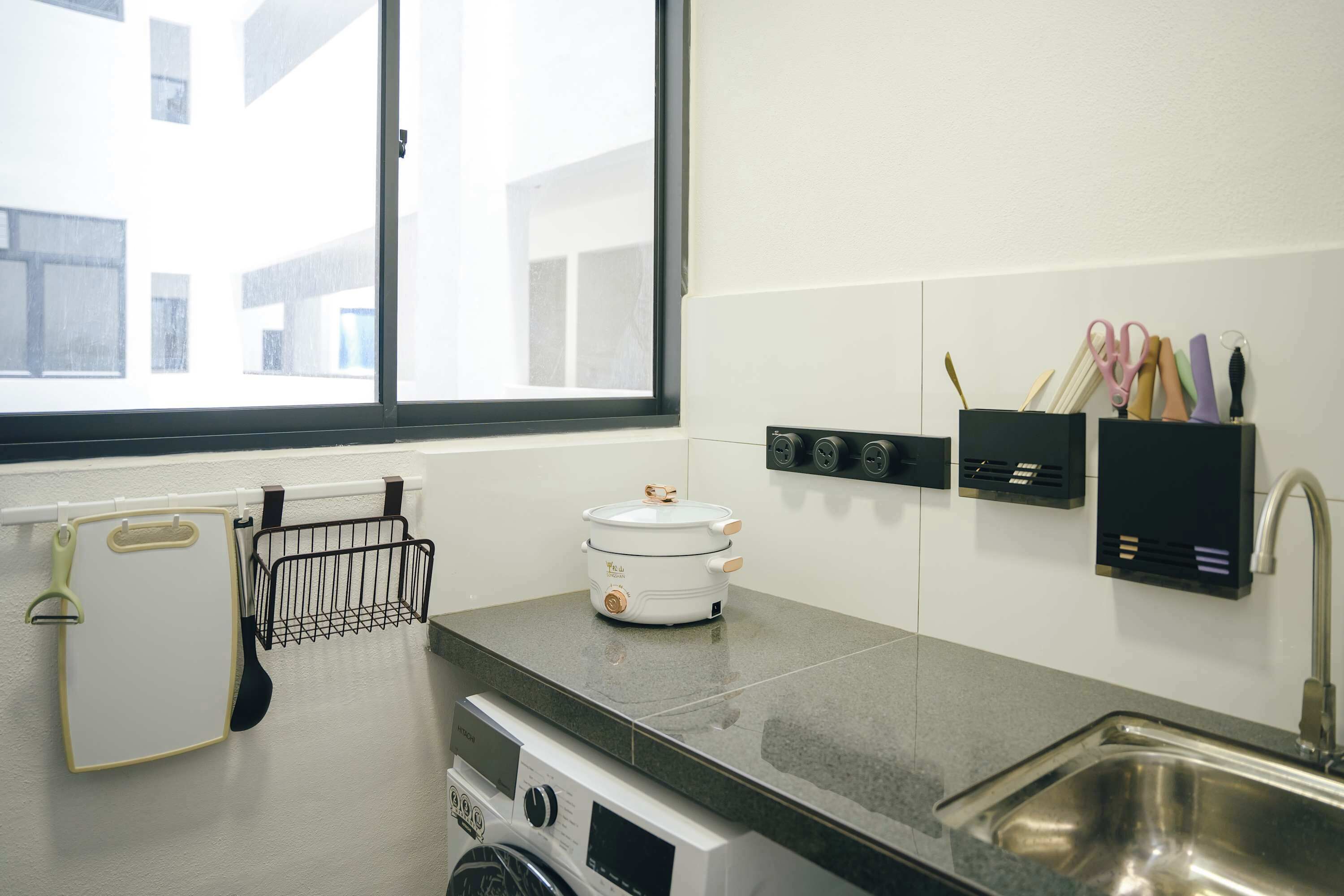 Una cucina moderna con forno integrato, lavello e finestra.