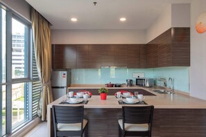 A modern kitchen with a central island, a dining area, and a view of the outside.
