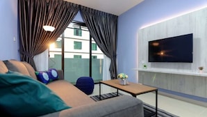 Ein modernes Wohnzimmer mit einer Couch, einem Couchtisch und einem an der Wand montierten Flachbildfernseher.