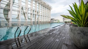 Ein Innenpool mit klarem Wasser, umgeben von einer Holzterrasse und Metallgeländern.