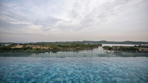 Vista chiara di una piscina con un fiume sullo sfondo e colline in lontananza.