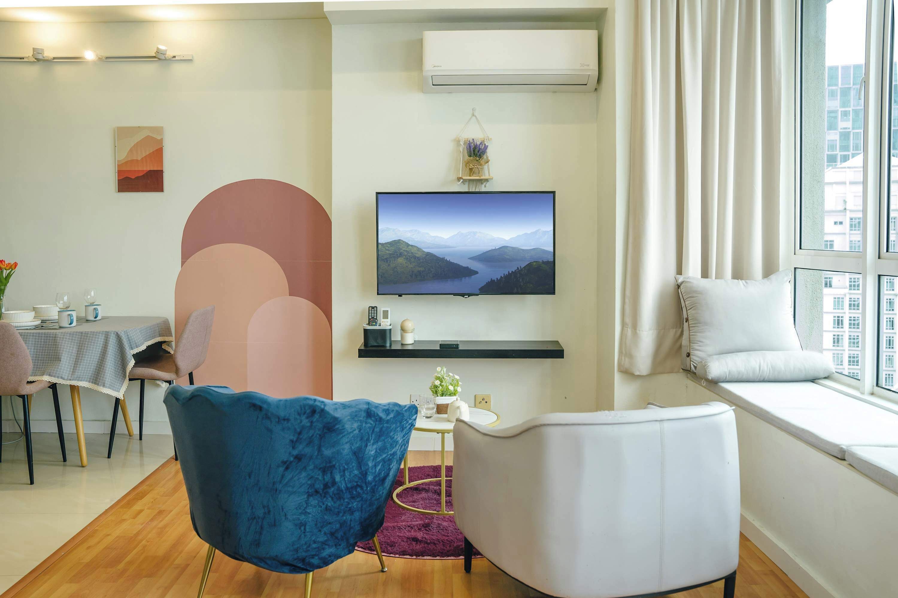 Una sala de estar moderna con televisor, asientos, comedor y ventana con vista a la ciudad.