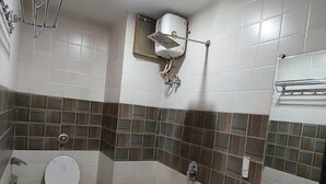 Une salle de bain avec des toilettes, un lavabo et une douche.