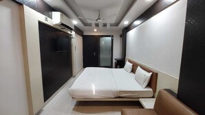 Une chambre d’hôtel équipée d’un lit, d’un bureau, d’une chaise, d’une armoire et d’un téléviseur.