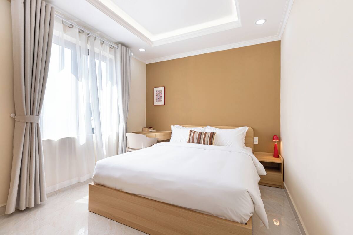 Una habitación de hotel moderna con una cama grande, un escritorio y una silla.