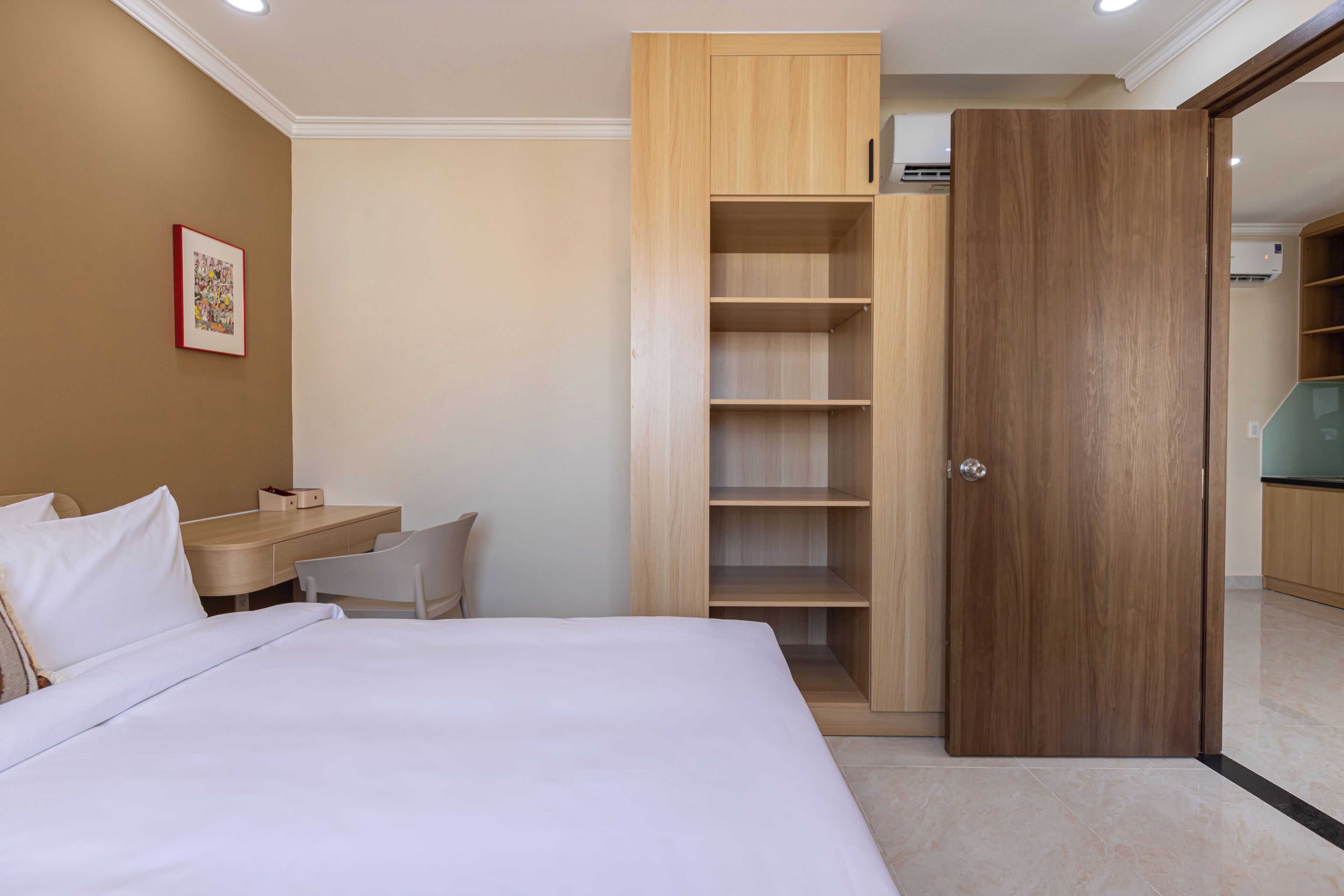 Una habitación de hotel con cama, escritorio y armario.