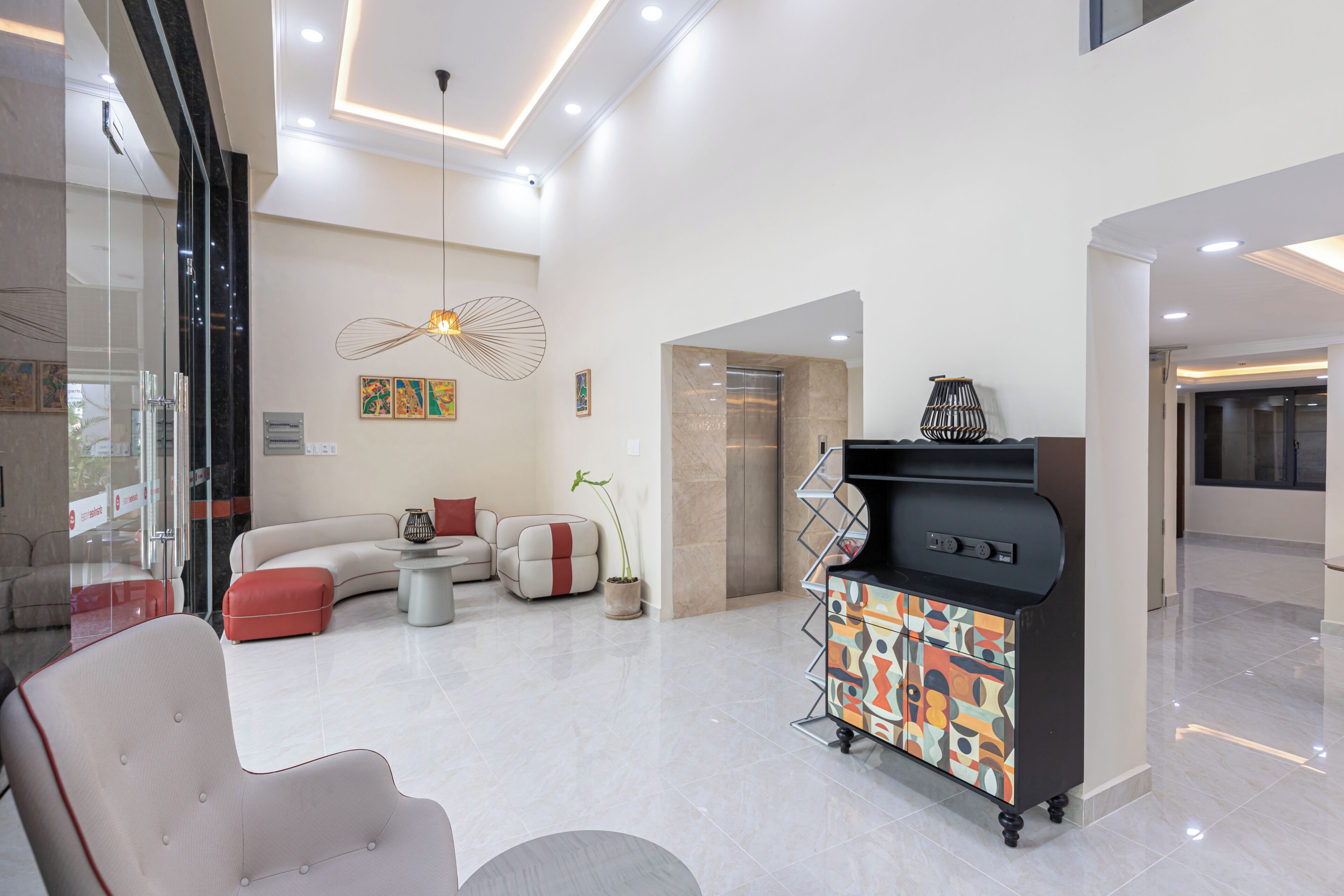 A spacious living area with a modern sofa, a small round table, and a decorative cabinet.
