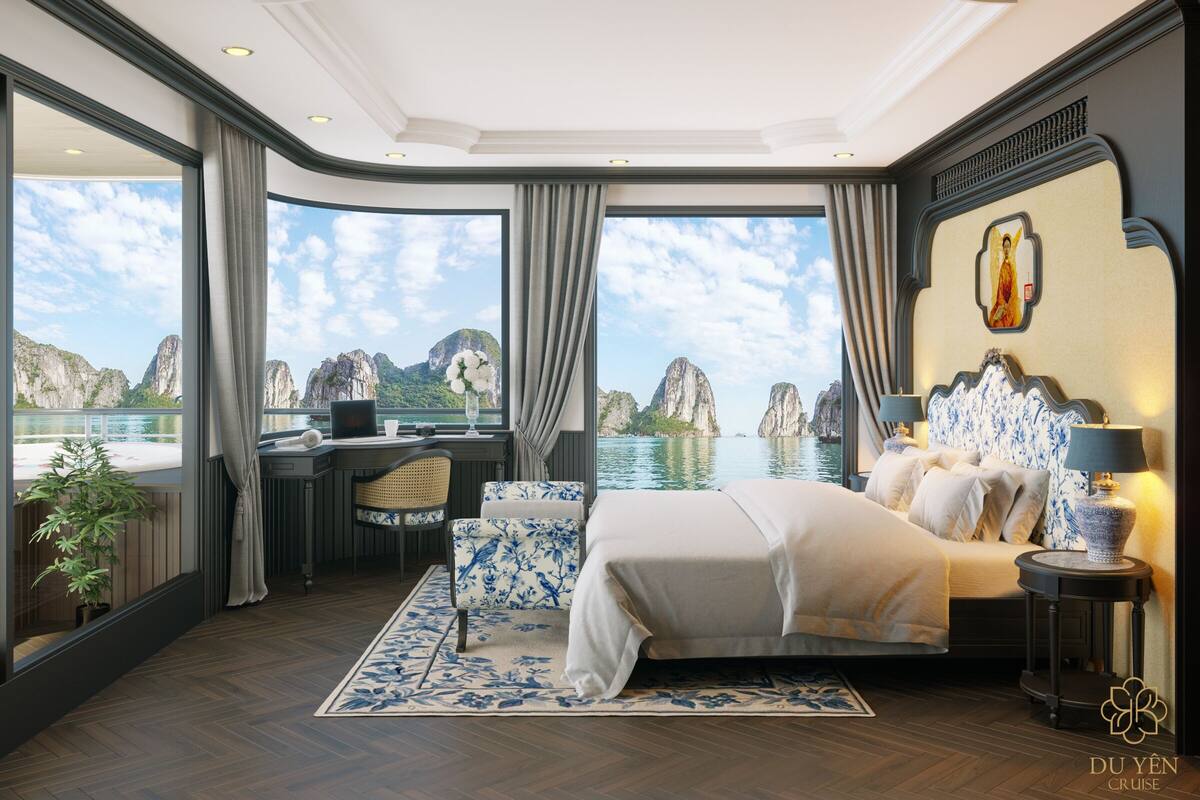 A luxurious bedroom with a large bed, a desk, and a view of the sea.