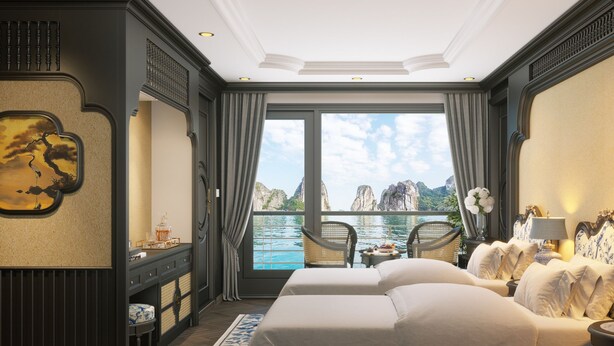 Un dormitorio lujoso con una cama grande, un escritorio y vista al agua.