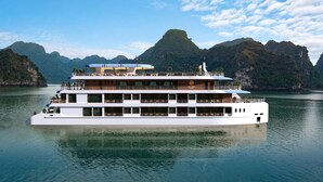 Un crucero moderno de varias cubiertas, con numerosos balcones y un logo que dice "DU YEN CRUISE".