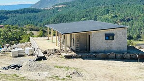 Un bâtiment doté d’un toit en pente, d’une petite fenêtre et de fondations en pierre.