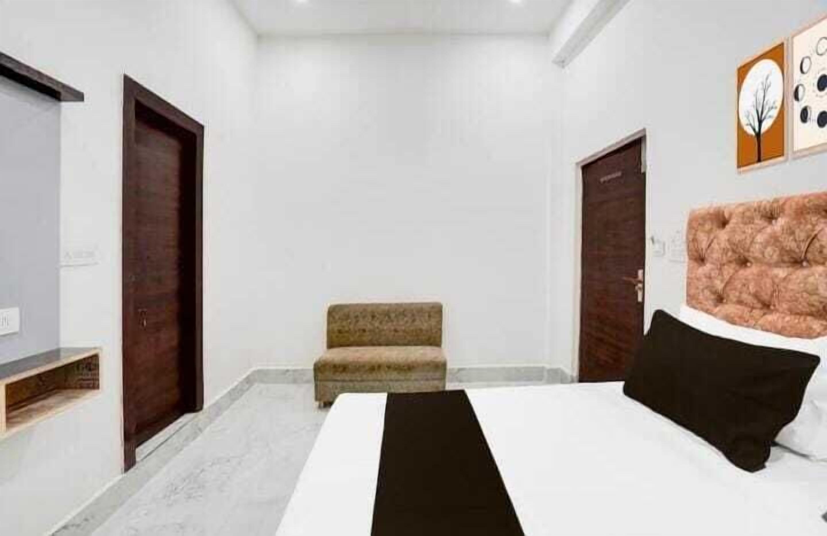 A bedroom with a bed, a sofa, and two doors.