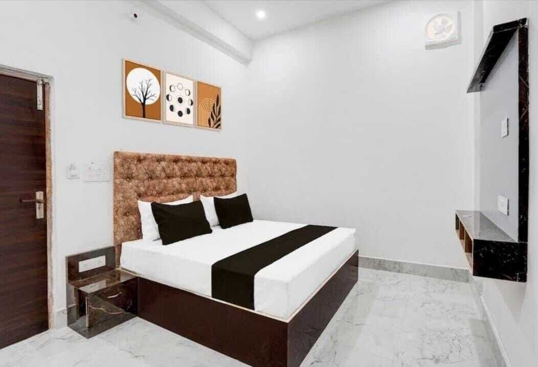 Un dormitorio moderno con una cama grande, un cabecero de diseño texturizado y una mesita de noche pequeña.