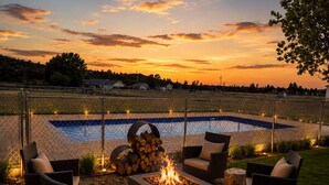 An outdoor patio with wicker furniture, a fire pit, and a pool. -  Stable House INN - Pool - Horse Farm - Hot Tub - Near Smith Rocks State Park (Redmond)