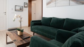 A living room with a green sofa, a wooden coffee table, and a potted orchid. - La Casita Fuengirola - Charming 3 bed ground floor (Fuengirola)