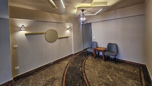 A modern hotel lobby with a marble floor, a round mirror, wall-mounted lights, and a chandelier. - Midpoint sea view - families only (Alexandria)