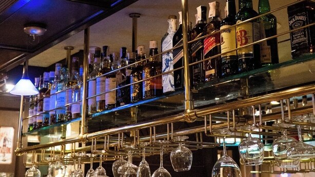 A bar area with a stained glass ceiling, shelves of liquor bottles, and hanging wine glasses. - Hotel Marine Plaza (Cox's Bazar)