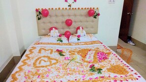 A neatly made bed with a tufted headboard, adorned with balloons and flowers. - Hotel Marine Plaza (Cox's Bazar)
