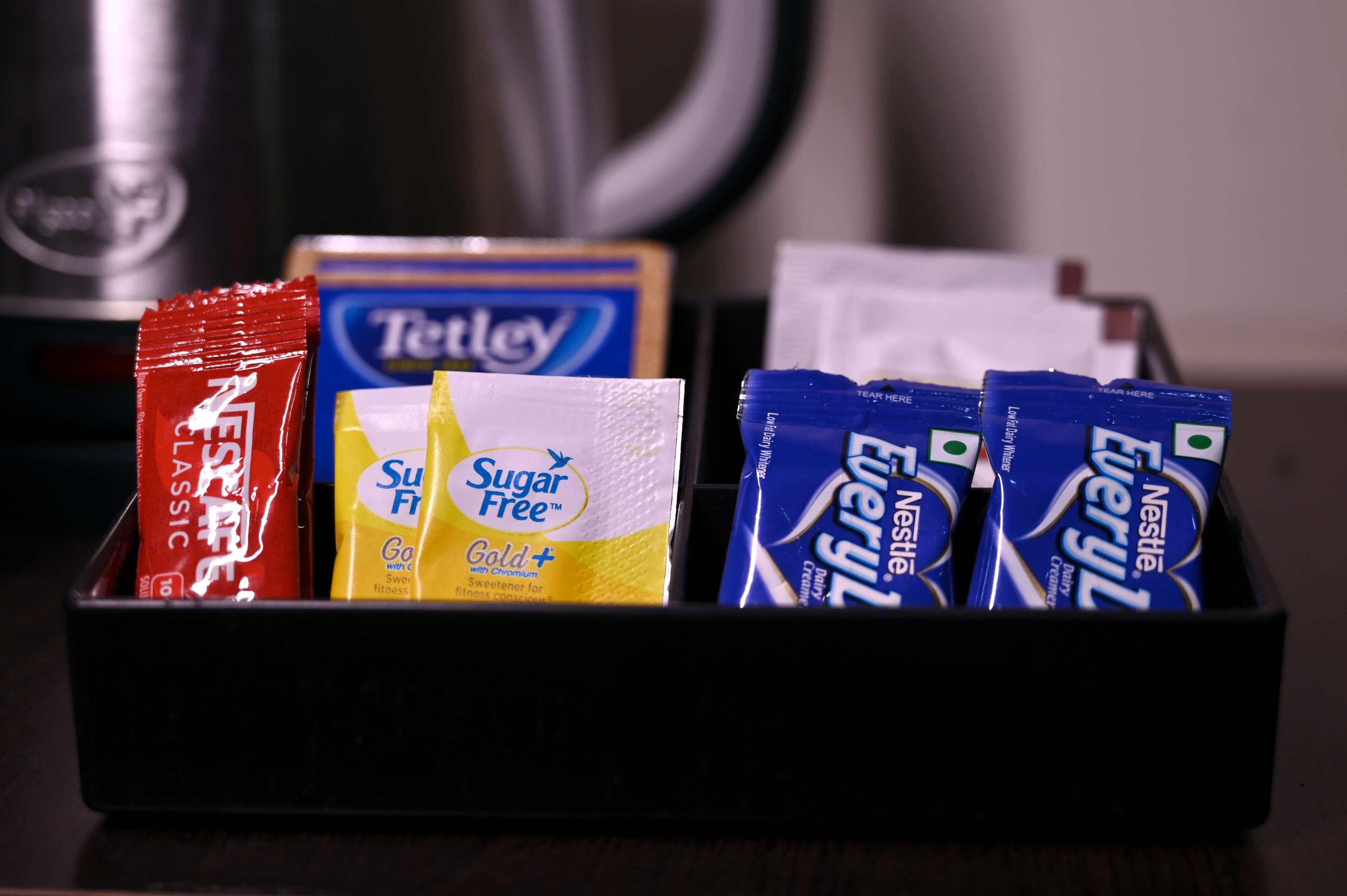 Un plateau contenant divers aliments, notamment des produits Nestlé Everly, des produits sans sucre et du thé Tetley.