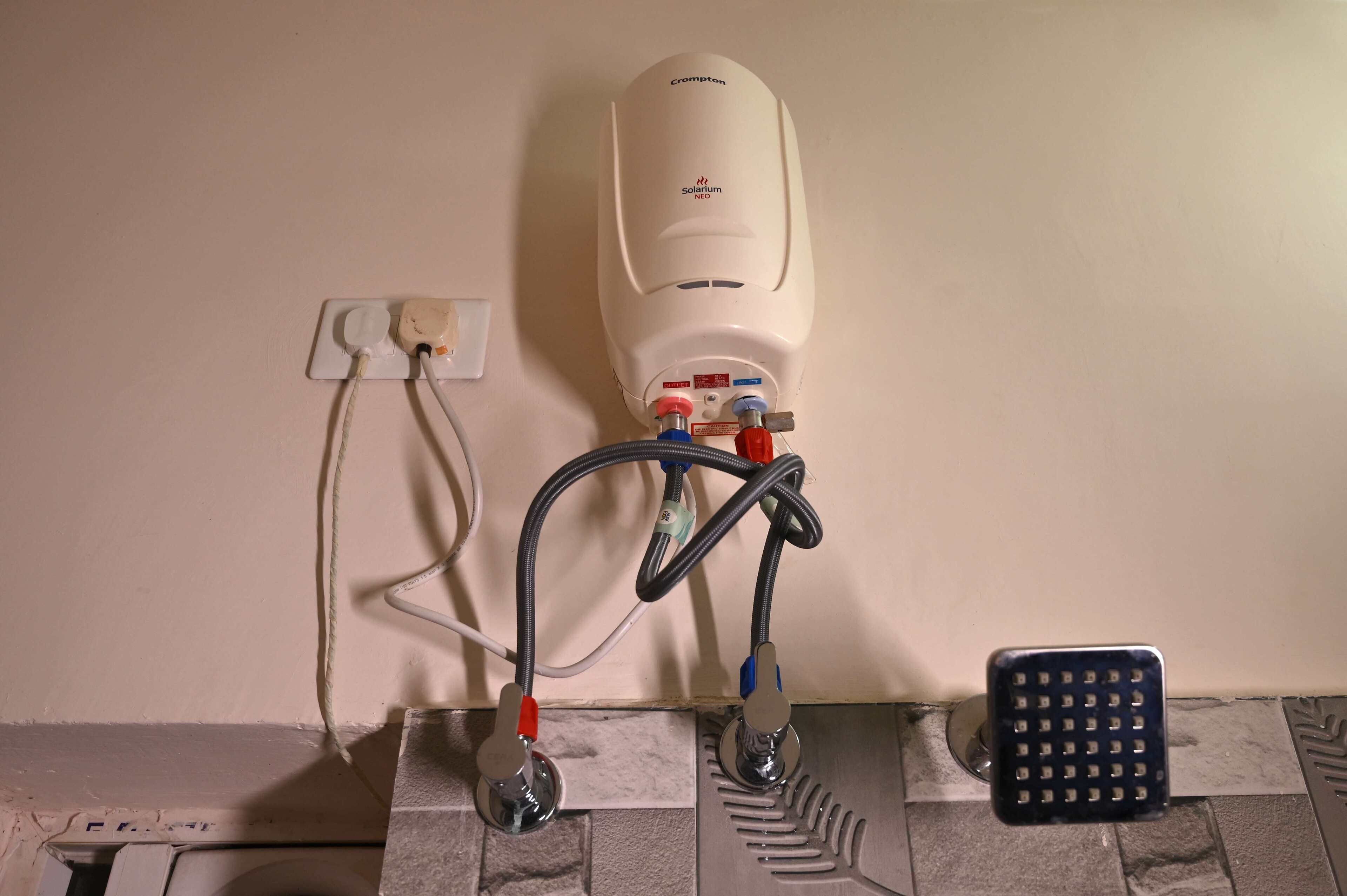 A wall-mounted air conditioning unit with visible wiring and a control panel.