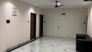 A spacious lobby with a marble floor, a ceiling fan, and a sign indicating a store room. - Stanza Premium Hotels (Bhubaneshwar)