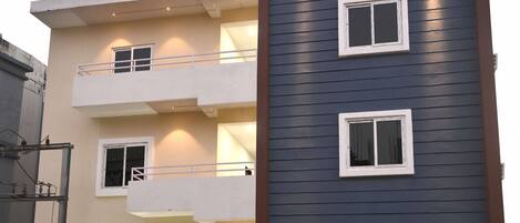A multi-story hotel with a modern facade, balconies, and a visible entrance.