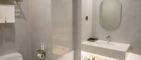 A modern bathroom with a toilet, a sink, a mirror, and a towel rack.