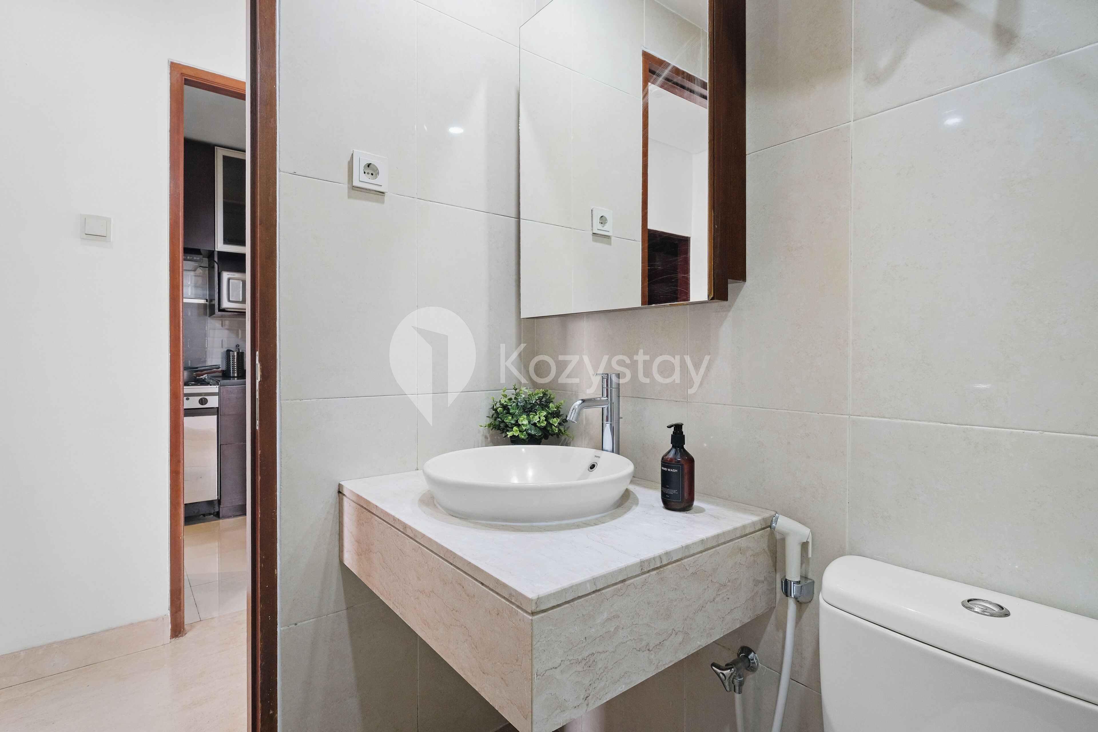A modern bathroom with a white sink, a mirror, and a toilet.
