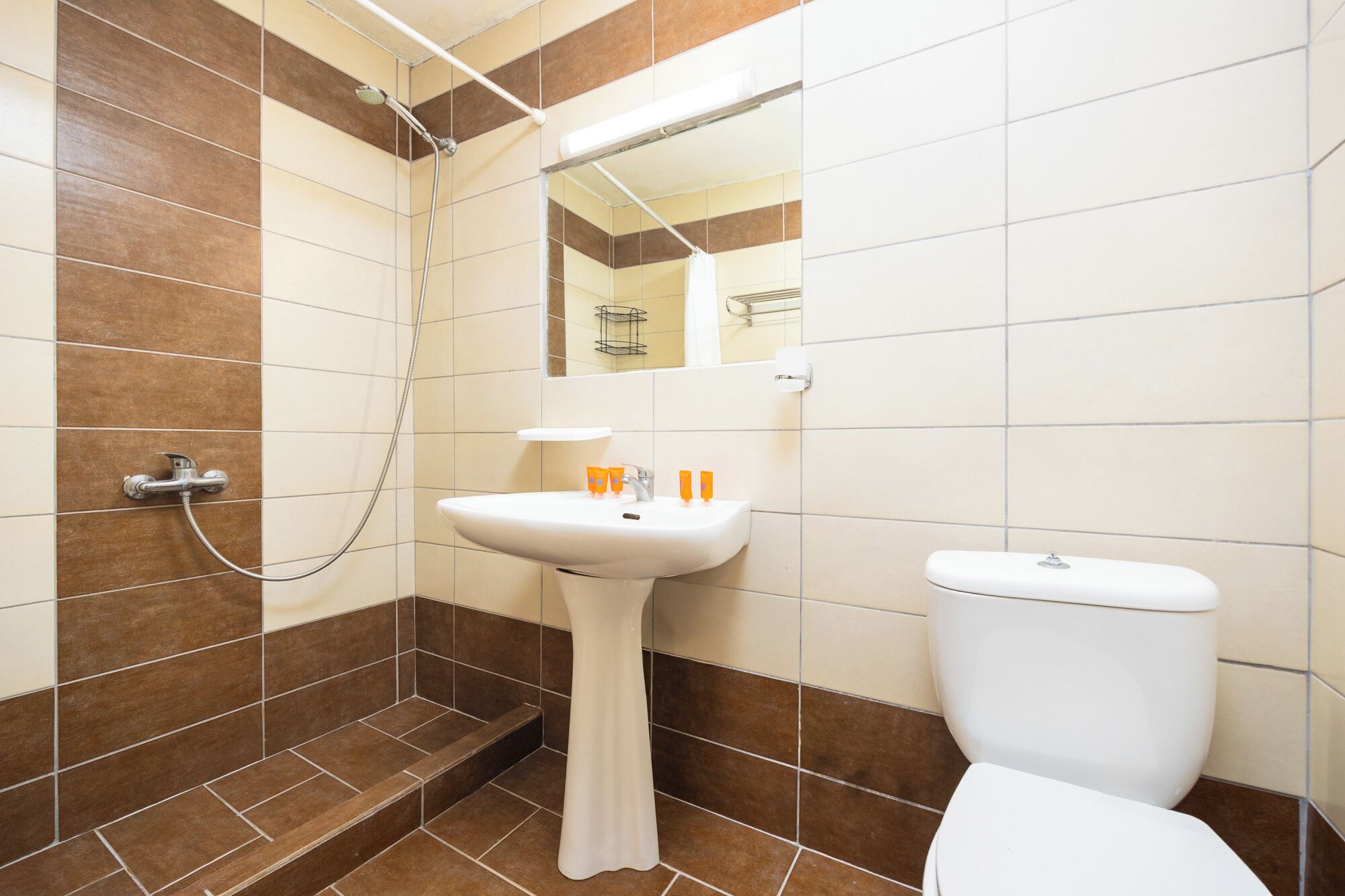 A bathroom with a white sink, a toilet, and a shower area.