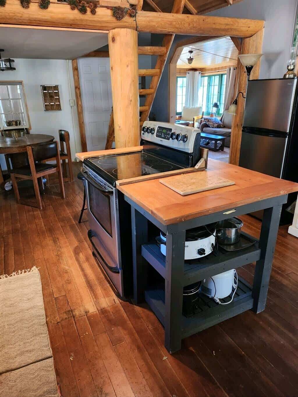 Eine rustikale Küche mit Holzofen, Holztisch und fest eingebautem Backofen.