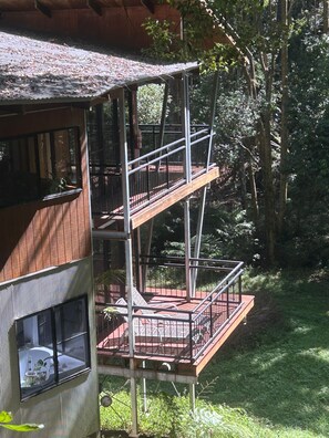 Una estructura de madera de varios niveles con balcones, rodeada de árboles.