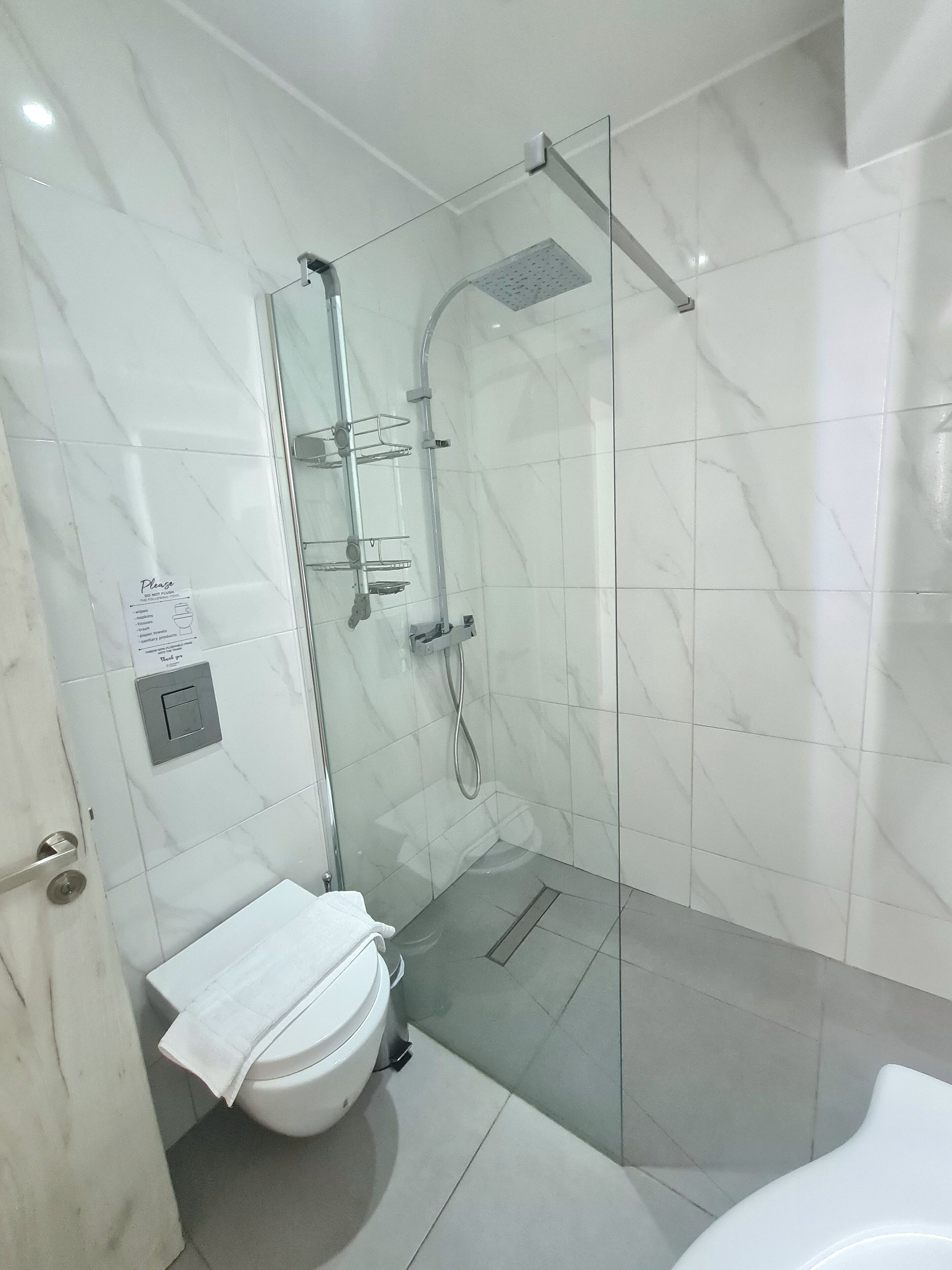 Une salle de bain moderne avec une douche à parois de verre, des toilettes et un lavabo.